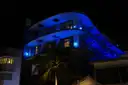 A curved Art Deco building lit blue at night