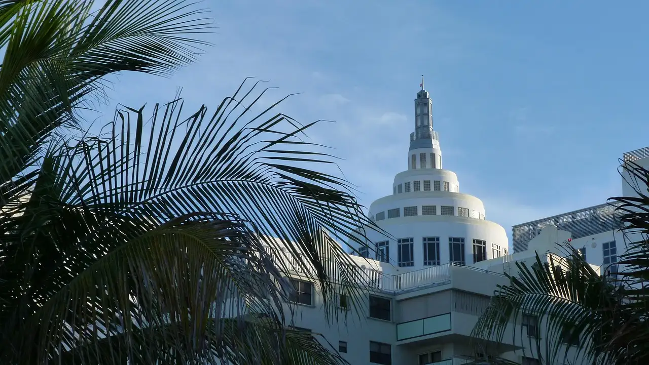 The stepped tower of an Art Deco hotel behind palm fronds