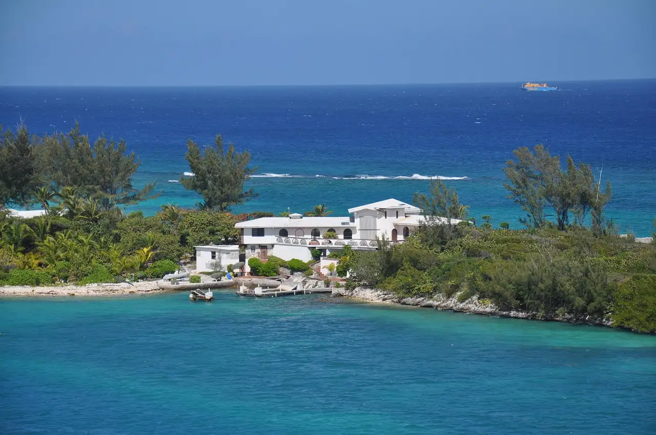 A small Bahamas island with houses and palm trees, ringed by turquoise water