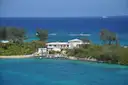 A small Bahamas island with houses and palm trees, ringed by turquoise water