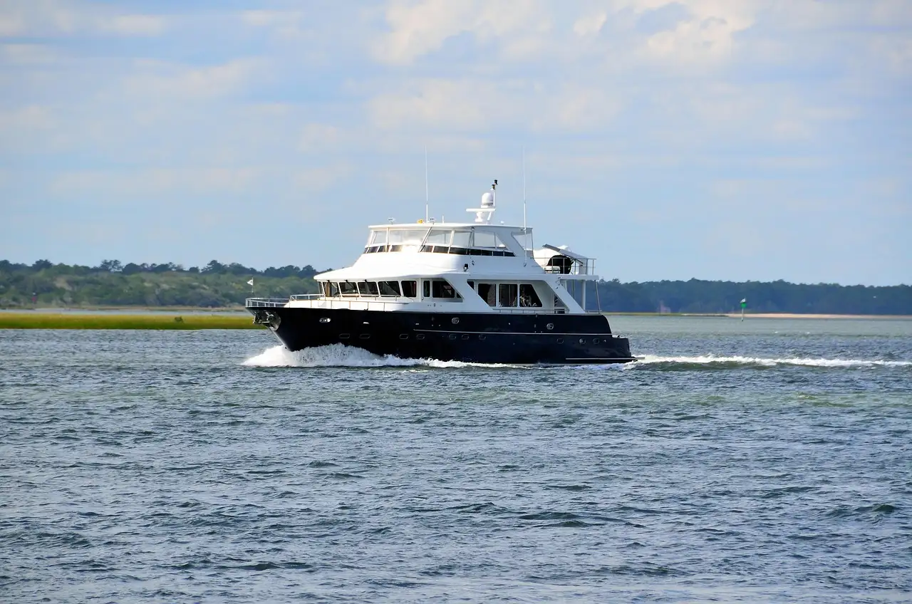 A black-hulled motor yacht underway on open water