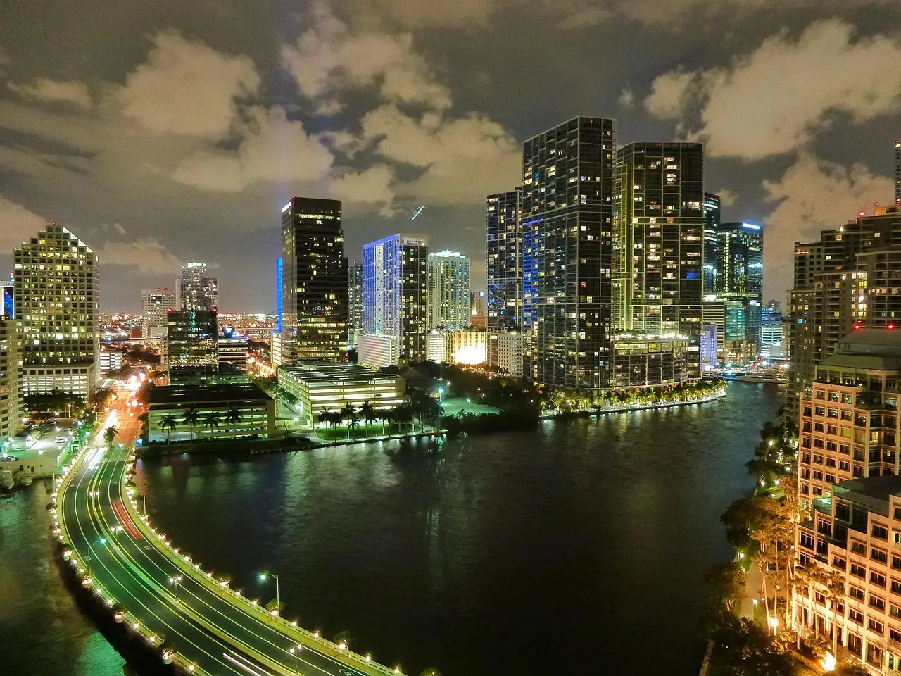 The Brickell district and Miami River lit up at night