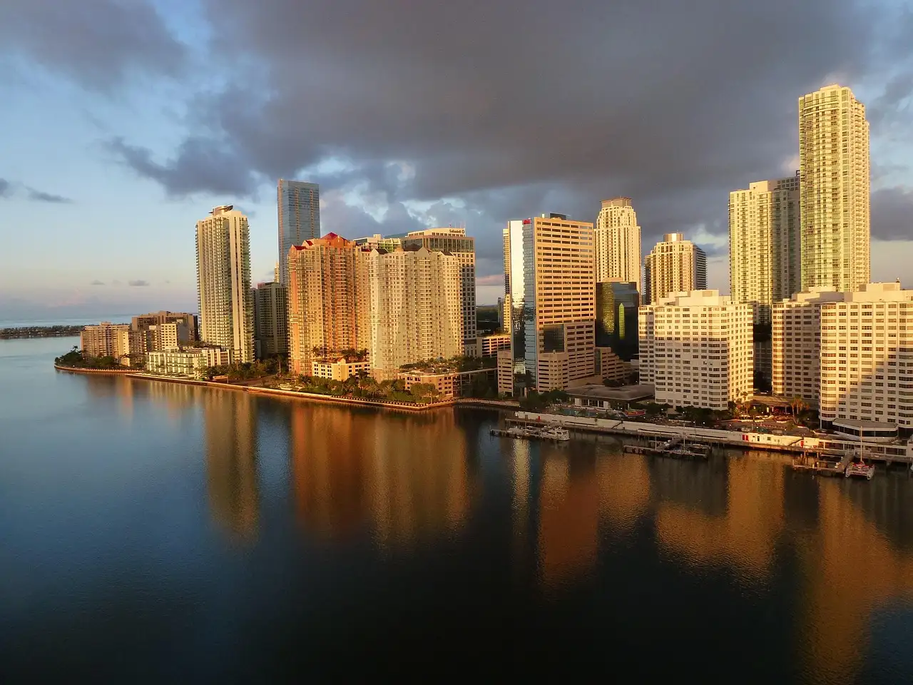 Brickell towers glowing in golden light, reflected in the bay