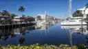 A calm canal with moored boats and palms