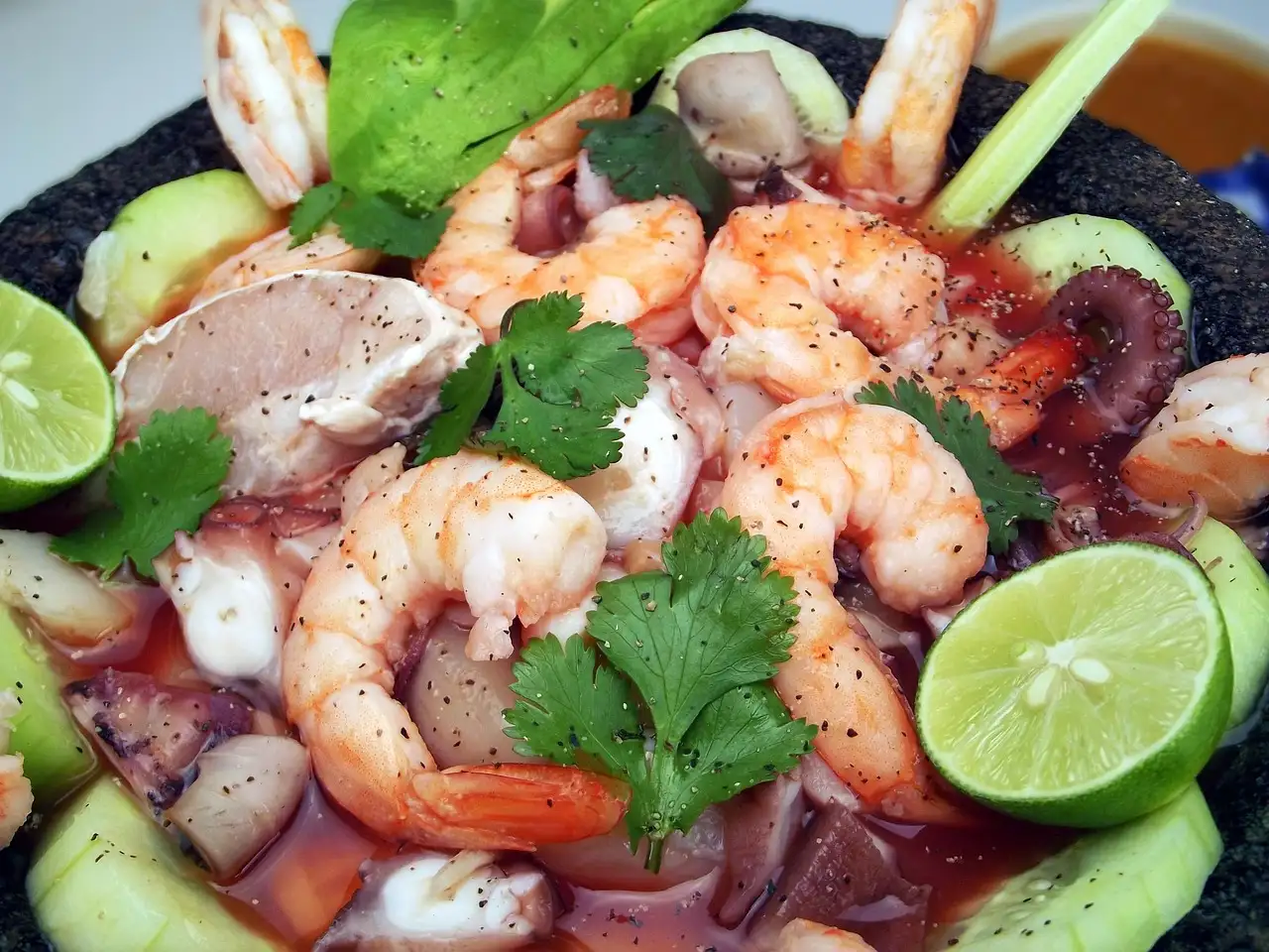 A plate of ceviche with shrimp and lime