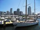 A classic sailing yacht in a Miami marina with the downtown skyline behind