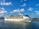 Cruise ship leaving Miami on blue water with the city skyline behind