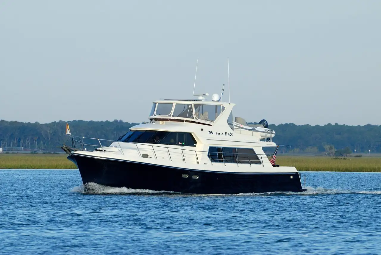 A dark-hulled motor yacht of about 50 feet cruising on calm water
