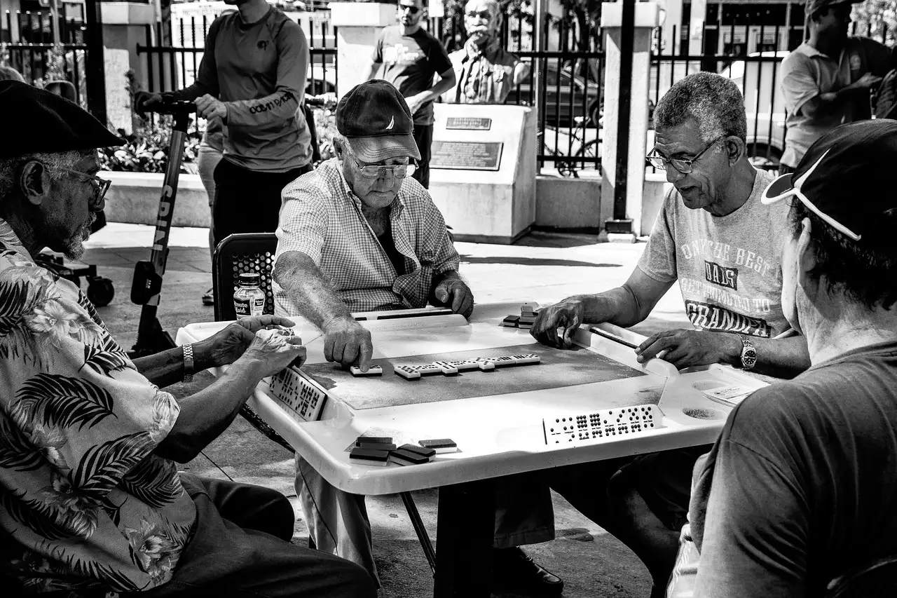 Men playing dominoes at a table in Domino Park, Little Havana