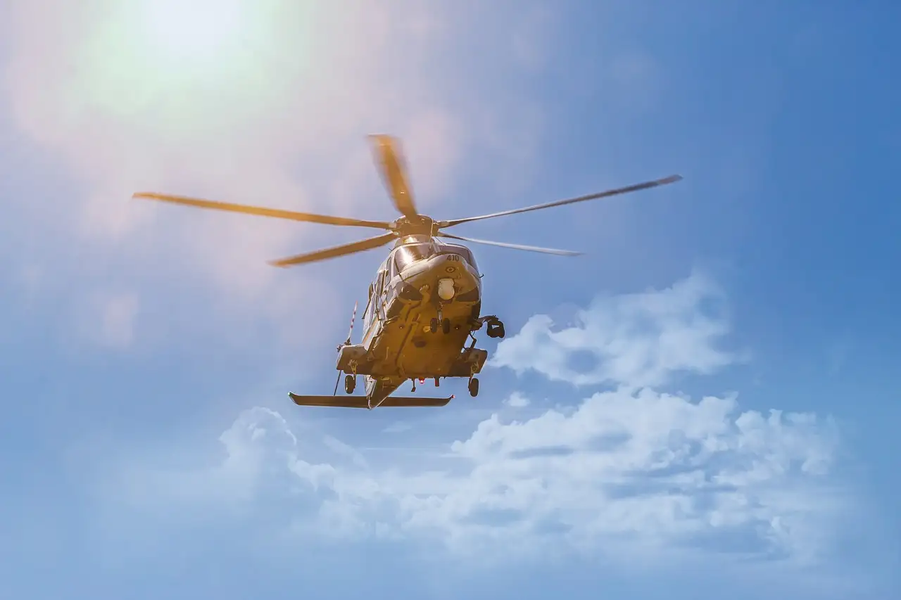 A helicopter flying among white clouds