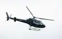 A helicopter in flight against a pale sky