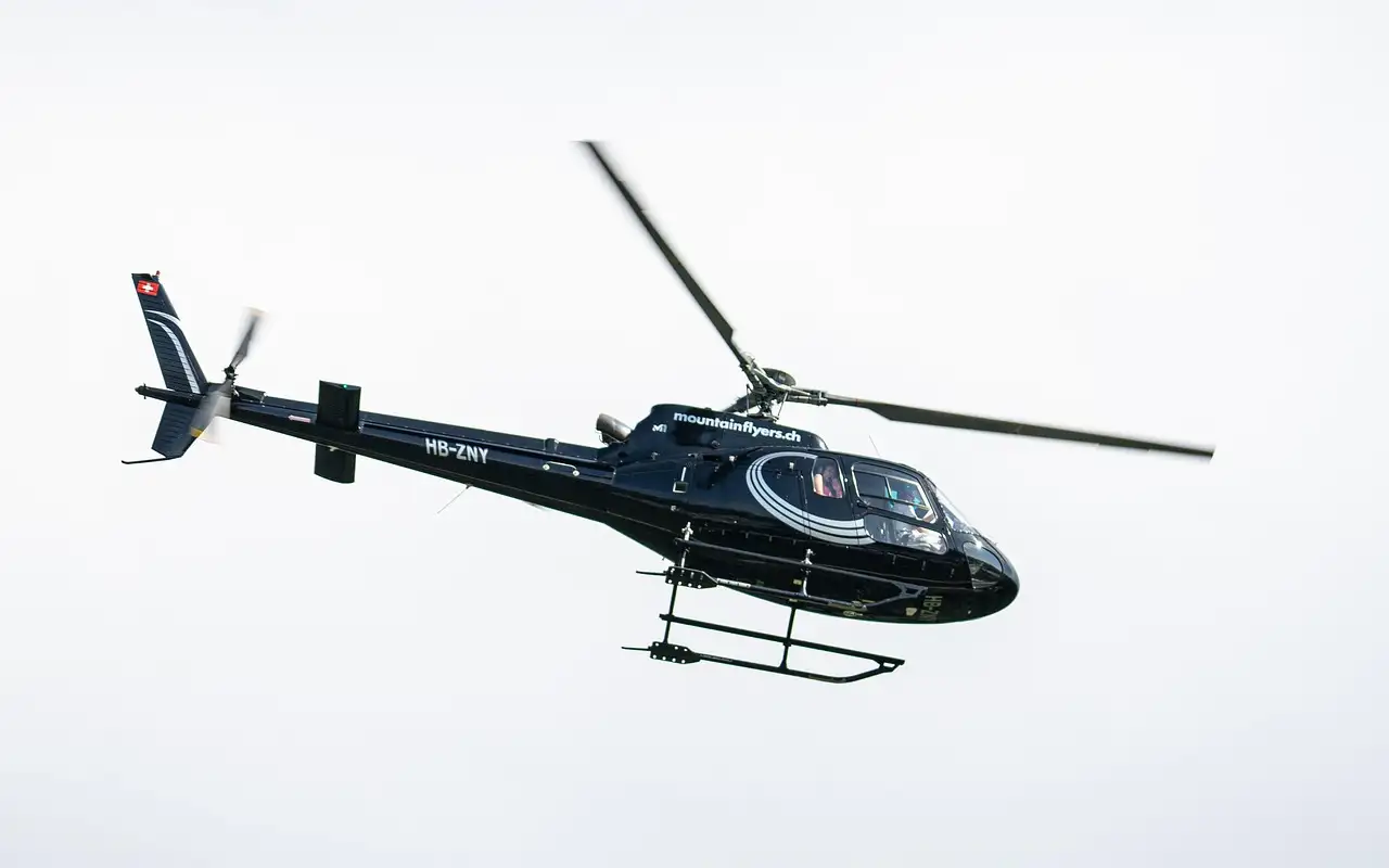 A helicopter in flight against a pale sky