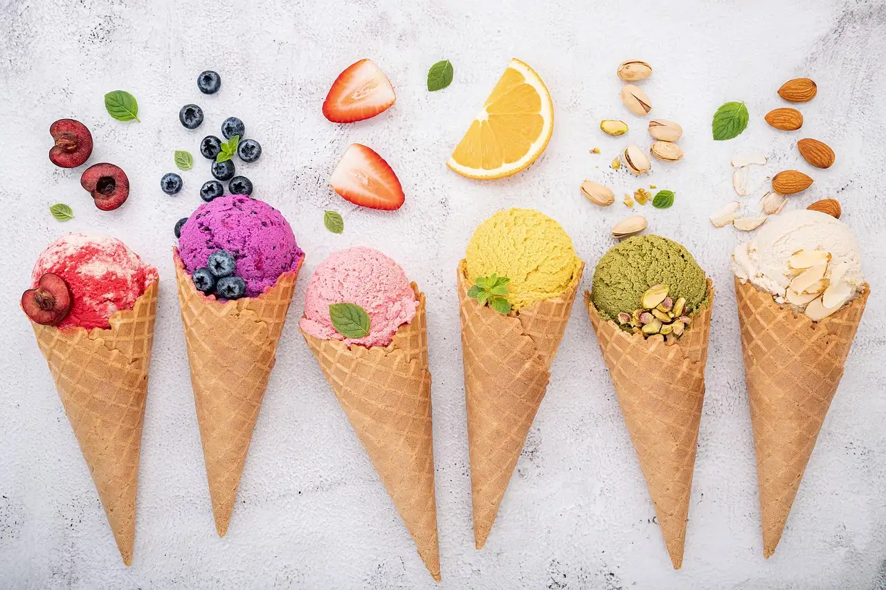 Ice cream cones in a row, topped with fruit