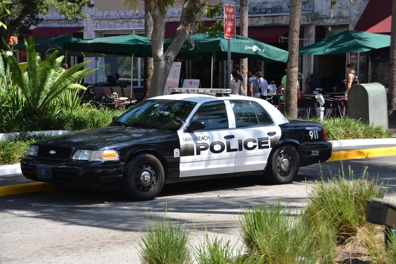 Police car parked on a South Beach street in front of cafe awnings