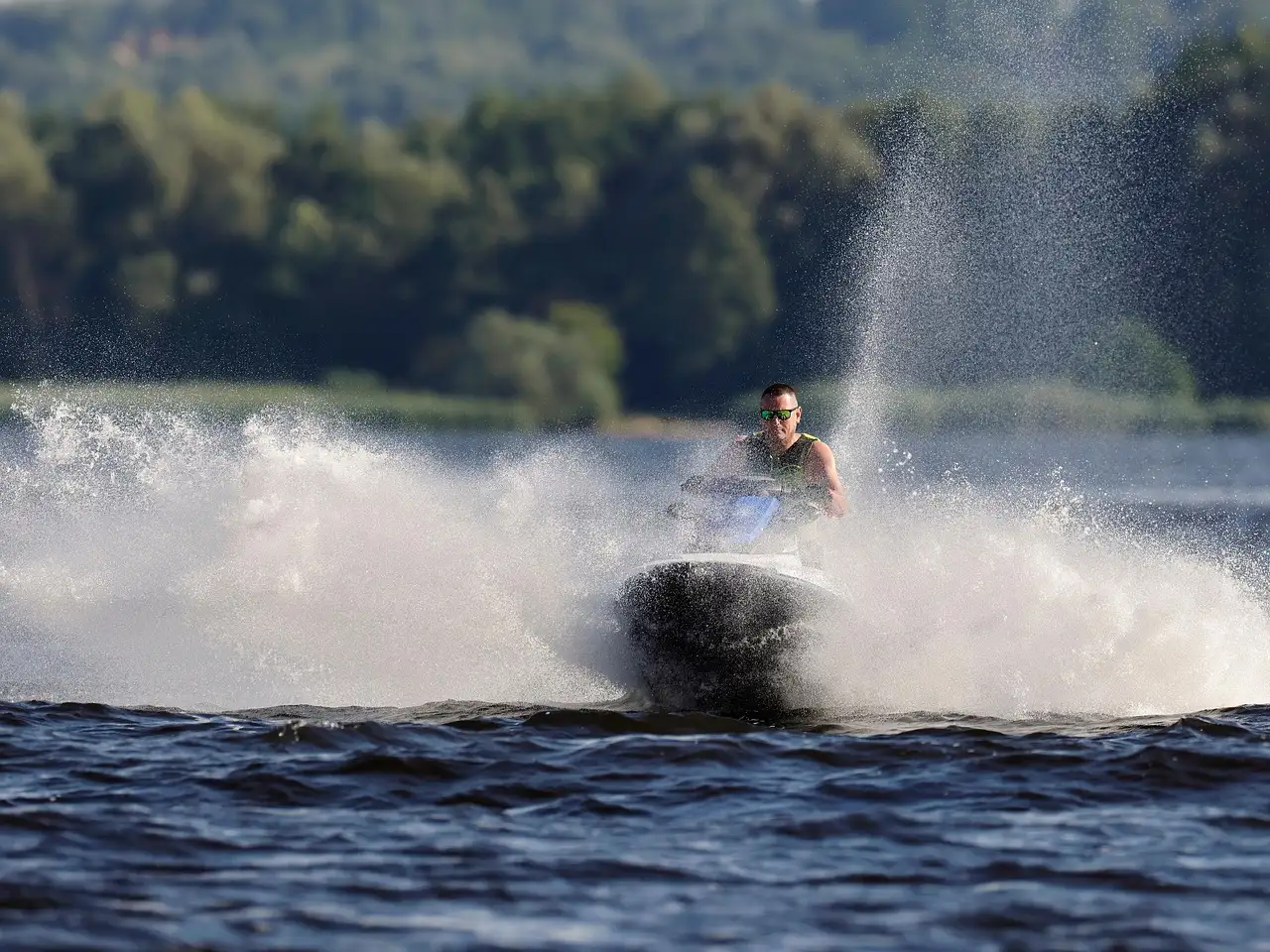 A jet ski rider throwing up a wall of spray