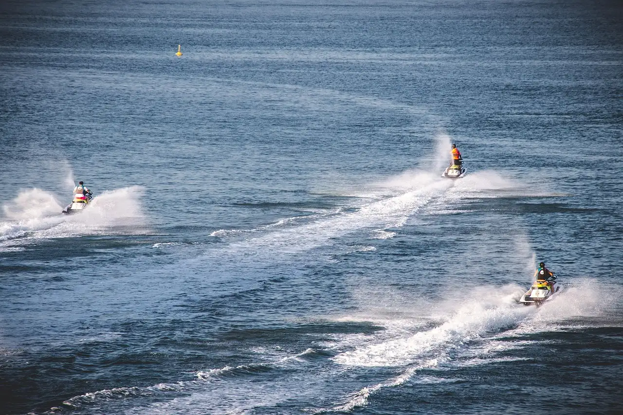 Jet skis leaving white wakes across the sea