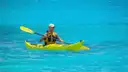 A kayaker paddling on bright turquoise water