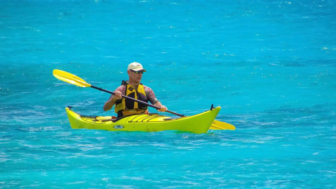 A kayaker paddling on bright turquoise water