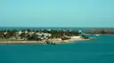 The Key West shore with palm trees and houses across turquoise water