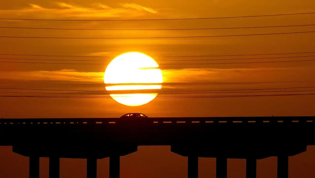 A Keys bridge in silhouette against a big setting sun