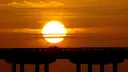 A Keys bridge in silhouette against a big setting sun