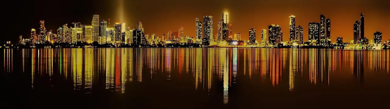 Miami skyline at night reflected in the water of Biscayne Bay