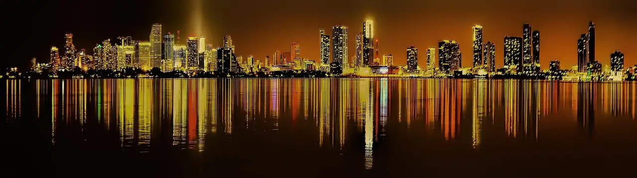 Miami skyline at night reflected in the water of Biscayne Bay
