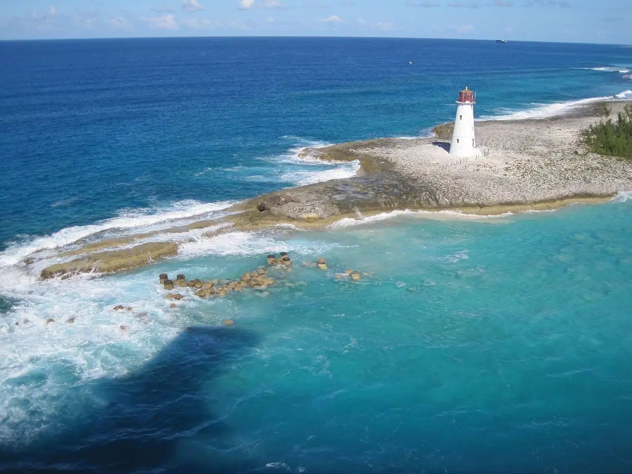 Lighthouse on the rocky shore of Paradise Island, Nassau, with turquoise water