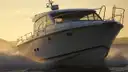 A white motor cruiser running through the waves at sunset