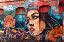 A large painted mural of a woman's face on a building