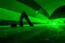 Green laser beams over raised hands in a nightclub