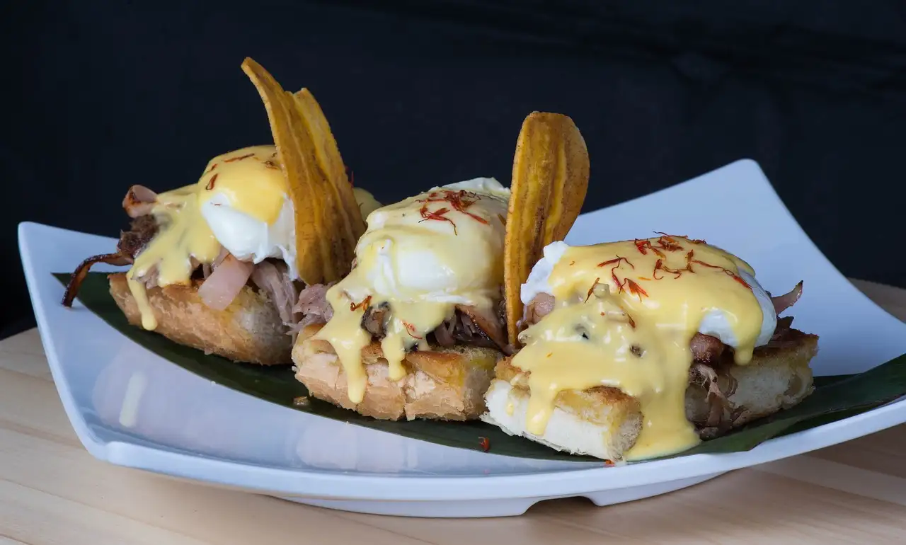 Small open sandwiches with sauce and plantain chips, served on a leaf
