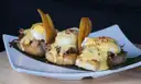 Small open sandwiches with sauce and plantain chips, served on a leaf