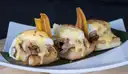 Toasted bread topped with pulled meat, sauce and fried plantain chips