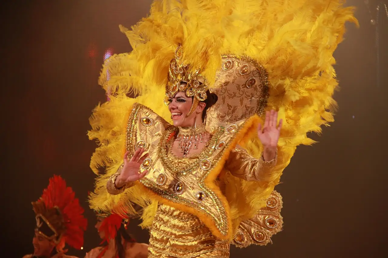 A show dancer in a gold costume with a large yellow feather headdress