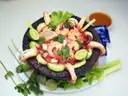 Shrimp ceviche with avocado and lime in a stone bowl