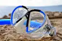 A snorkel mask lying on rocks by the sea