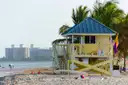 A lifeguard tower on South Beach with palms and hotels behind