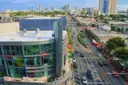 Aerial view of a busy sunlit street in Miami Beach with traffic and shops