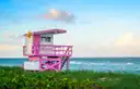 A pink lifeguard tower on South Beach with the sea behind