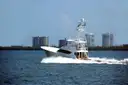 A sportfishing boat heading out past waterfront condos