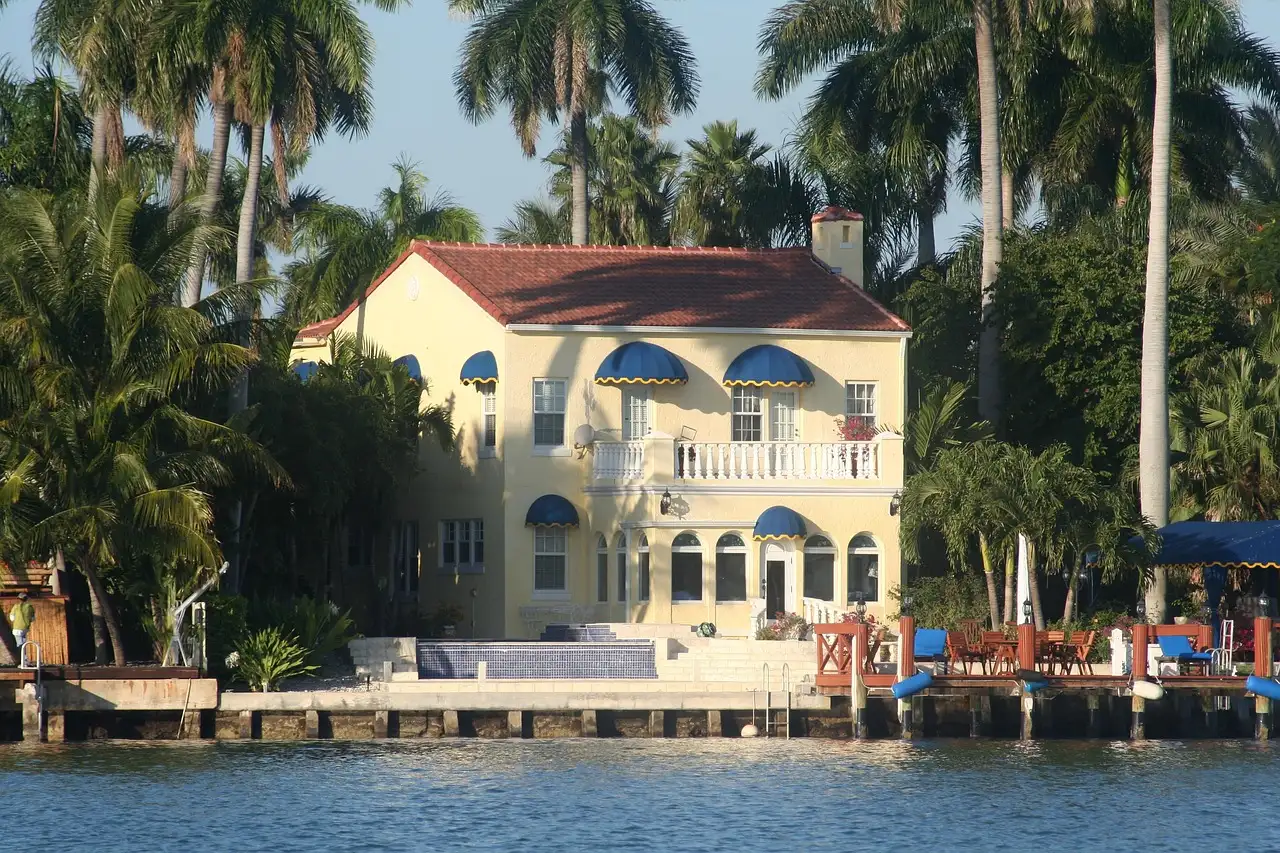 A waterfront mansion with palm trees and a private dock on Biscayne Bay