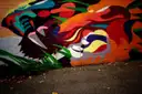 A bold street-art mural in red, orange and black
