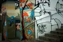 A black-and-white tree mural painted on walls and stairs