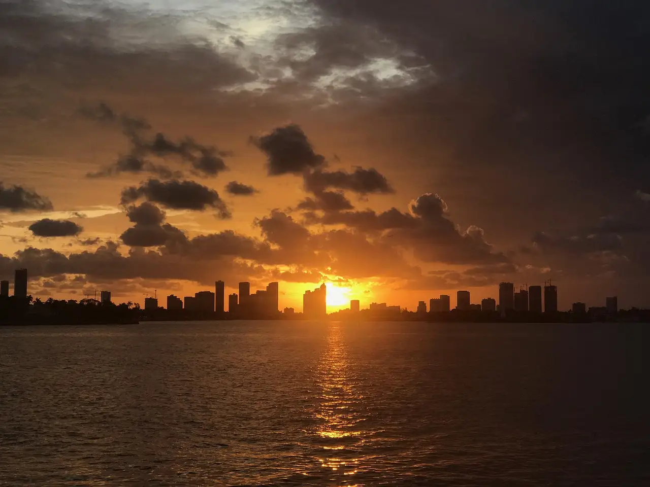 Sun setting behind the Brickell skyline across Biscayne Bay
