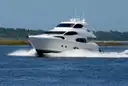 A white motor yacht of about 60 feet cruising at speed